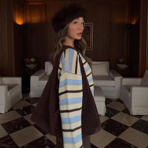 Chic oversized striped knit cardigan in pastel colors with a vintage interior backdrop