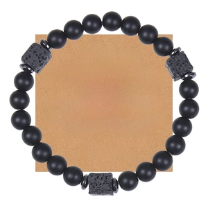 Close-up of black matte stone bead bracelet with lava rock accents on a gift message card