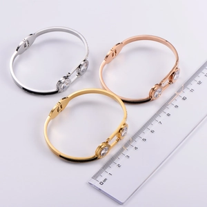 Detail of three-color stainless steel hinged bangles with Roman numerals and cubic zirconia
