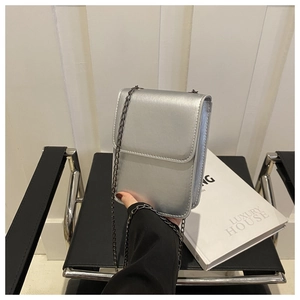 Detail of silver metallic PU leather phone bag with vertical flap and dark chain strap