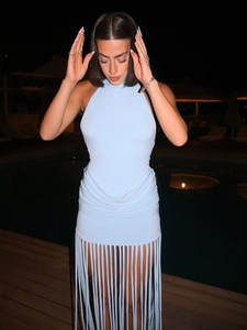 Detail of light blue halter neck dress featuring gathered waist and long tassel fringe