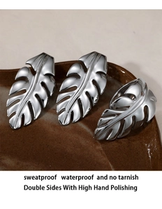 Macro shot of polished silver leaf earrings showing tarnish-free stainless steel texture