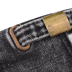 Detail of adjustable brass buckle and vintage washed denim texture on baseball cap