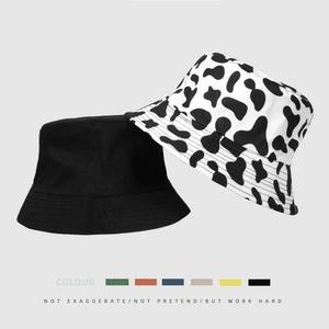 Dual-sided bucket hat with classic cow print and solid black minimalist design