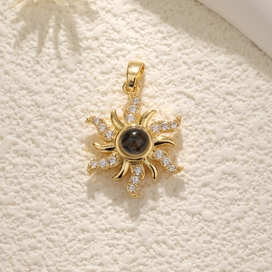 Elegant gold sun-shaped pendant necklace with sparkling zircons and a central dark stone
