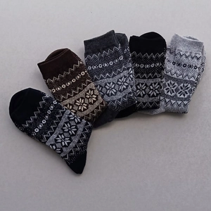 Detail showing five pairs of thick wool socks with Nordic snowflake patterns