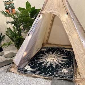 Bohemian sun moon star camping blanket used as a rug inside an Indian style teepee tent