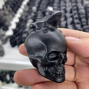 Macro view of hand-carved obsidian frog on skull figurine with polished textures