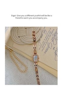 Detail of rose gold square watch with rhinestone bezel on a vintage lace background