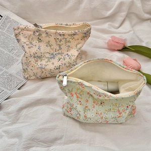 Detailansicht floraler Canvas-Kosmetiktaschen mit Metallreißverschluss auf weißem Stoff