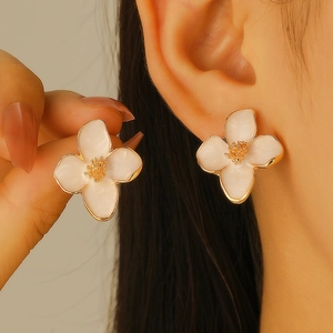 Sweet white enamel flower stud earrings with gold metal centers in a 3D floral design