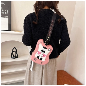 Detail view of pink guitar-shaped crossbody bag with star rivets and wing decor