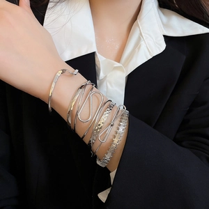 Silver bangle set showing layered styling of minimalist metallic bracelets on a model wrist