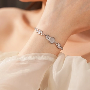 Detail of silver gourd charm bracelet with shimmering zircons on model's wrist