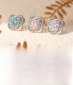 Makroansicht von Kleeblatt-Ohrsteckern mit blauen, rosa und weißen Zirkonia-Steinen