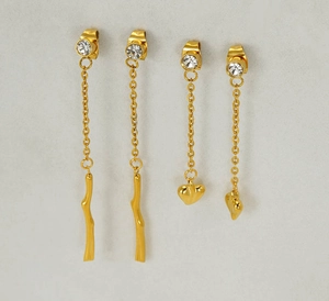 Detail of gold tassel earrings featuring sparkling rhinestones and heart branch shapes