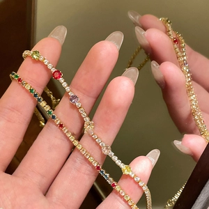 Detail of gold plated tennis bracelet with colorful round zircon stones and crystal accents