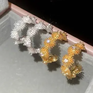 Sparkling gold and silver flower C-shaped earrings with zircons in a jewelry box