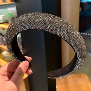 Close-up of a thick padded headband covered in shimmering silver rhinestones and crystals