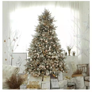 Luxurious Christmas tree detail with gold ornaments, snow-dusted pine, and joy wooden sign