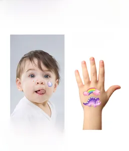 Close-up show of colorful watercolor dinosaur glitter tattoos on skin and hand