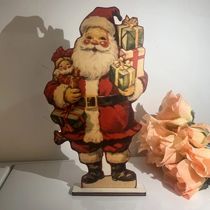 Close-up of vintage wooden Santa Claus table decoration holding a gift box