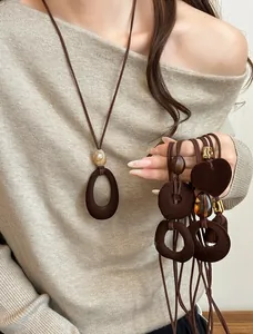 Detail of vintage long pendant necklace with resin beads and dark brown cord on model