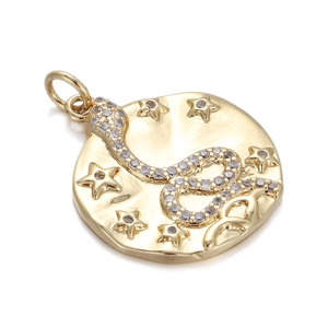 Close-up of golden round pendant with embossed snake and star design and clear stones