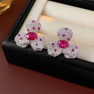 Close-up of vintage flower earrings with red oval stones and pink crystals in a black box