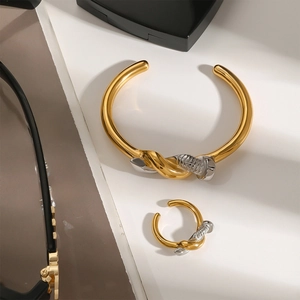 Parure bague et bracelet clou bicolore en acier titane plaqué or 18 carats sur support