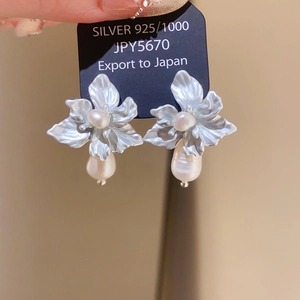 Detail of S925 silver flower earrings with white pearls and hanging teardrop pearl charm