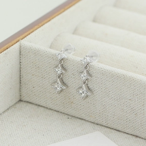Détail macro de boucles d'oreilles en argent S925 avec pendentifs étoile et zircon