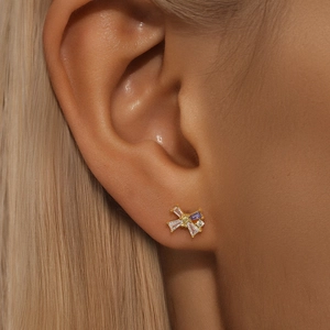 Detailed view of gold bow earrings featuring purple and white marquise-cut zircons