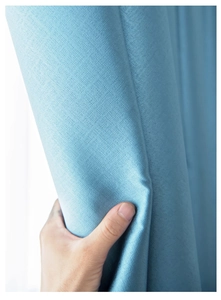 Close-up of blue blackout curtain fabric texture with thick material and smooth drape