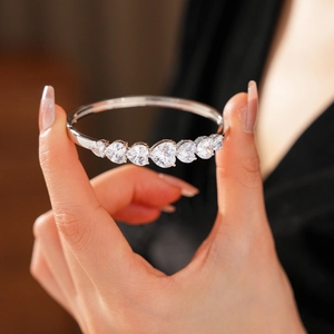 Détail des pierres de zircone en forme de cœur sur un bracelet en argent poli