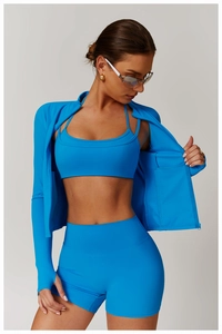 Detail of bright blue yoga set featuring zip-up jacket with thumbholes and shorts