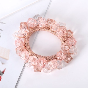 Close-up of pink and clear multi-faceted crystal beads on an elastic hair tie