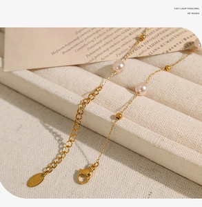 Detail of 18K gold star pearl necklace featuring lobster clasp and extension chain