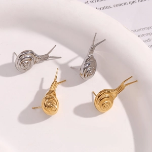 Macro detail of snail shaped stud earrings in gold and silver stainless steel finish