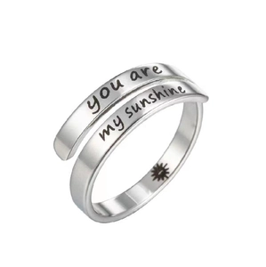 Macro detail of 'you are my sunshine' engraving on silver-toned adjustable open ring