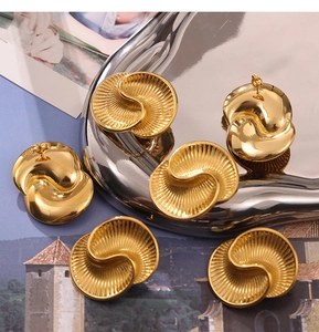 Detailed view of gold asymmetric earrings featuring unique pleated and mirror-finish textures