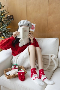 Thick coral fleece Christmas socks in red and white stripes shown in a festive home setting