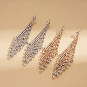 Macro detail of long layered rhinestone tassel earrings in silver and gold plating