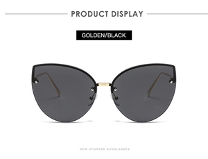 Close-up of golden metal frame and black lenses on fashion cat eye sunglasses