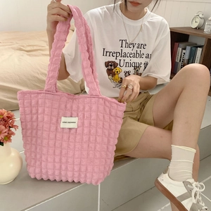 Dettaglio della borsa rosa trapuntata con etichetta Love Sozakka e consistenza morbida