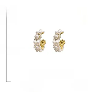 Detail showing S925 silver needle on C-shaped pearl and rhinestone gold earrings