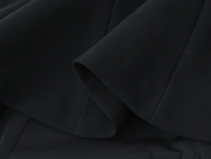 Close-up of the black elastic fabric texture and draped hem detail of the tank top