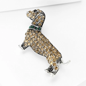 Close-up of dachshund brooch with amber and green crystals on silver alloy base
