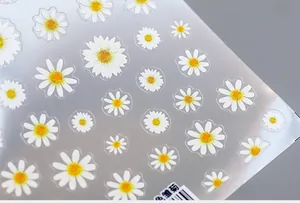Macro view of 5D white daisy nail art stickers with yellow centers and fine petal textures