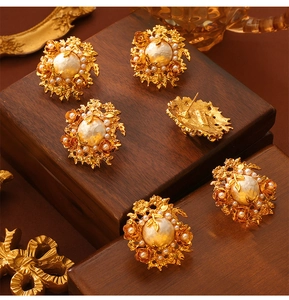Detailed shot of baroque flower earrings with cream pearls and gold-tone petals